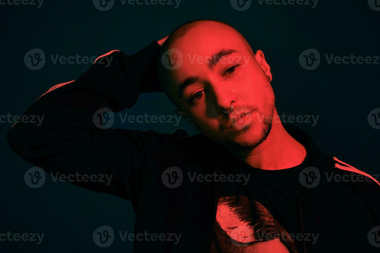 estúdio tiro do uma jovem tatuado Careca homem posando contra uma colorida fundo. anos 90 estilo. foto