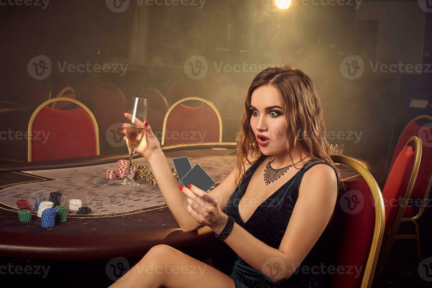 jovem lindo fêmea é posando sentado em uma cadeira contra uma pôquer mesa dentro luxo casino. foto