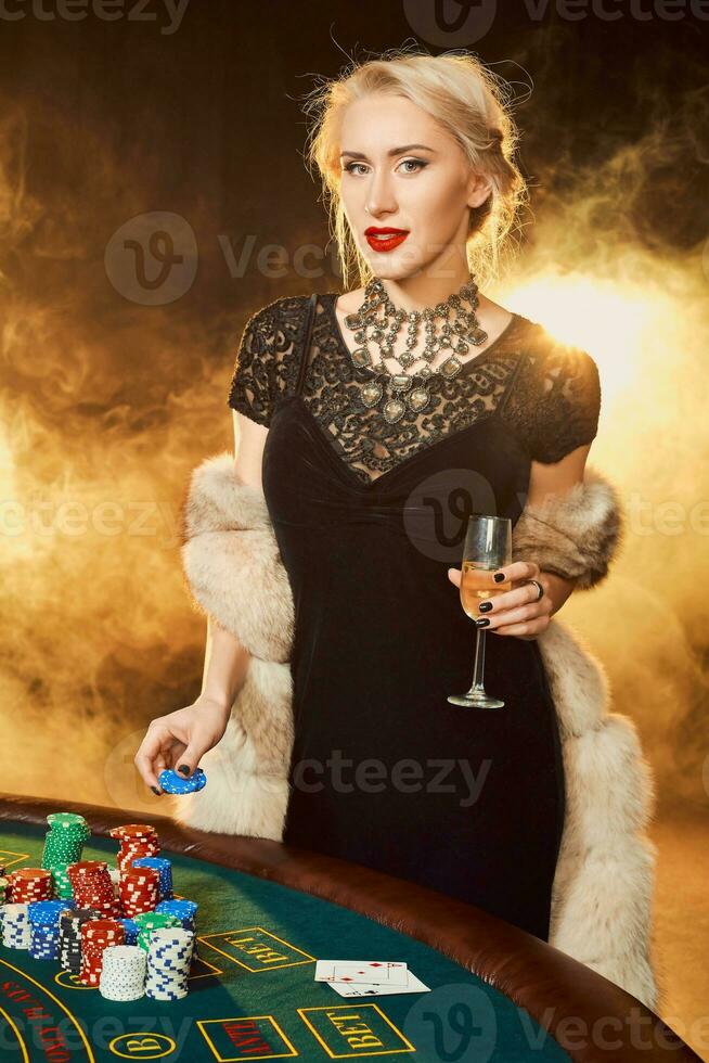 retrato do mulher guardando pôquer salgadinhos perto mesa dentro cassino foto