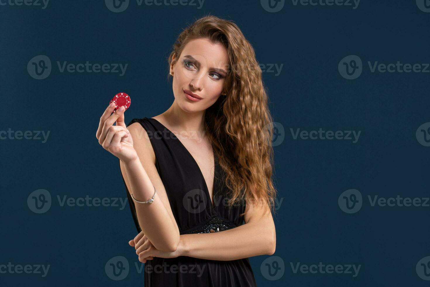retrato do a fêmea jogador às a cassino guardando pôquer salgadinhos dentro a mão foto