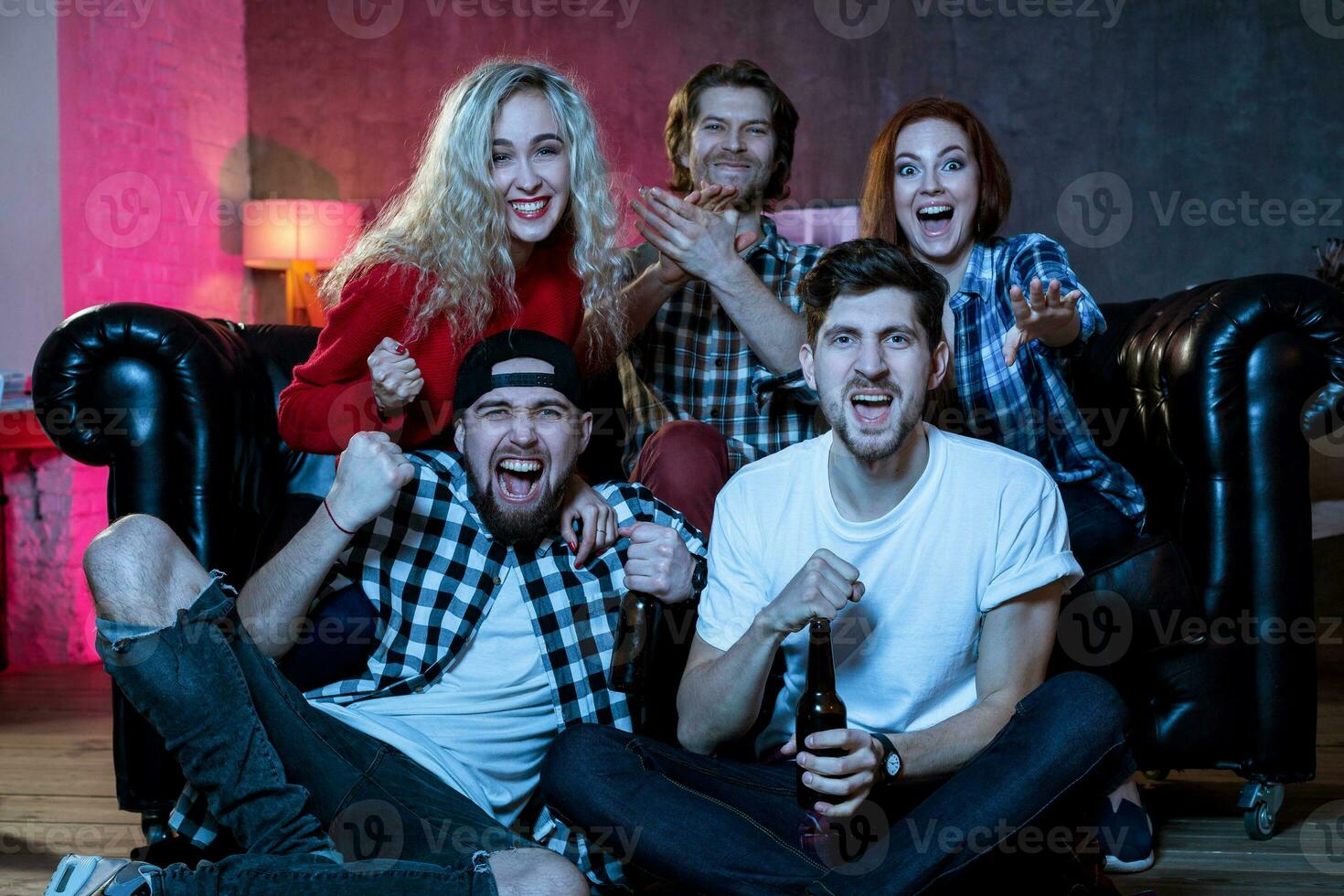 grupo do amigos tendo Diversão às casa, observando jogos e desfrutando t foto