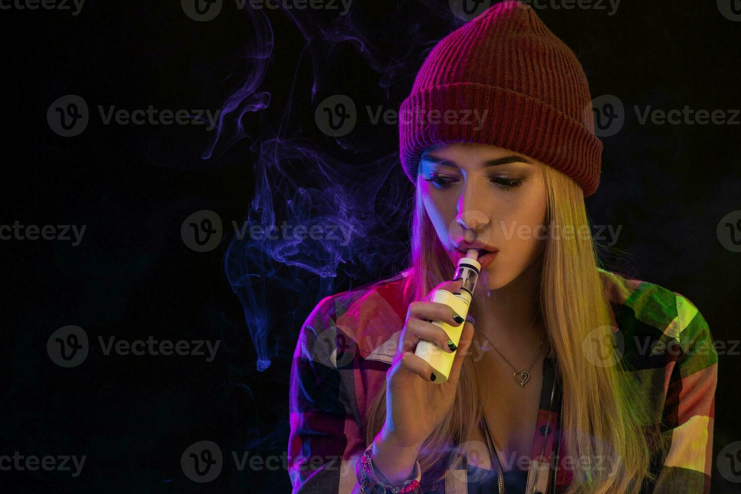 Cigarro eletrônico garota. jovem hipster mulher vape e-cig em estúdio em Preto fundo. hip-hop estilo. fechar acima. foto