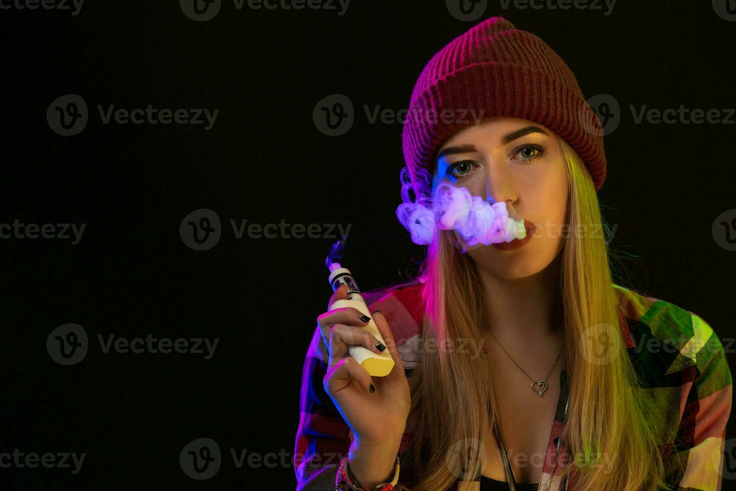 Cigarro eletrônico garota. jovem hipster mulher vape e-cig em estúdio em Preto fundo. hip-hop estilo. fechar acima. foto