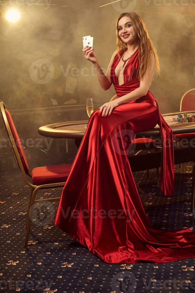 jovem lindo mulher é posando contra uma pôquer mesa dentro luxo casino. foto