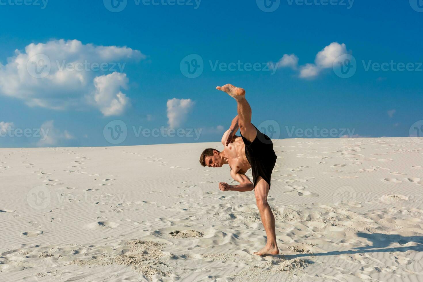 retrato do jovem Parkour homem fazendo giro ou cambalhota em a areia. foto