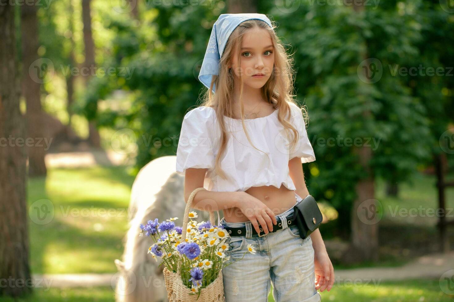 Adolescência menina com cesta do flores silvestres em pé dentro verão parque do país Estado foto