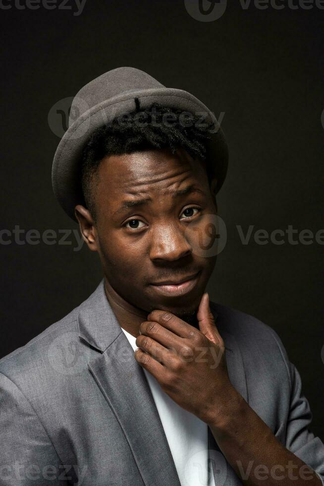 retrato do uma elegante africano americano homem sorridente em Preto fundo foto