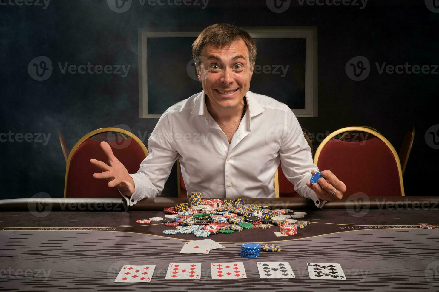 bonito emocional homem é jogando pôquer sentado às a mesa dentro casino. foto