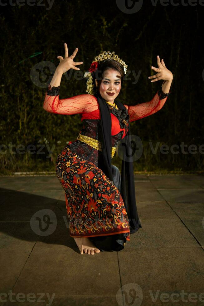 uma javanese dançarino danças dentro frente do a público com a ágil corpo dentro uma Preto traje foto