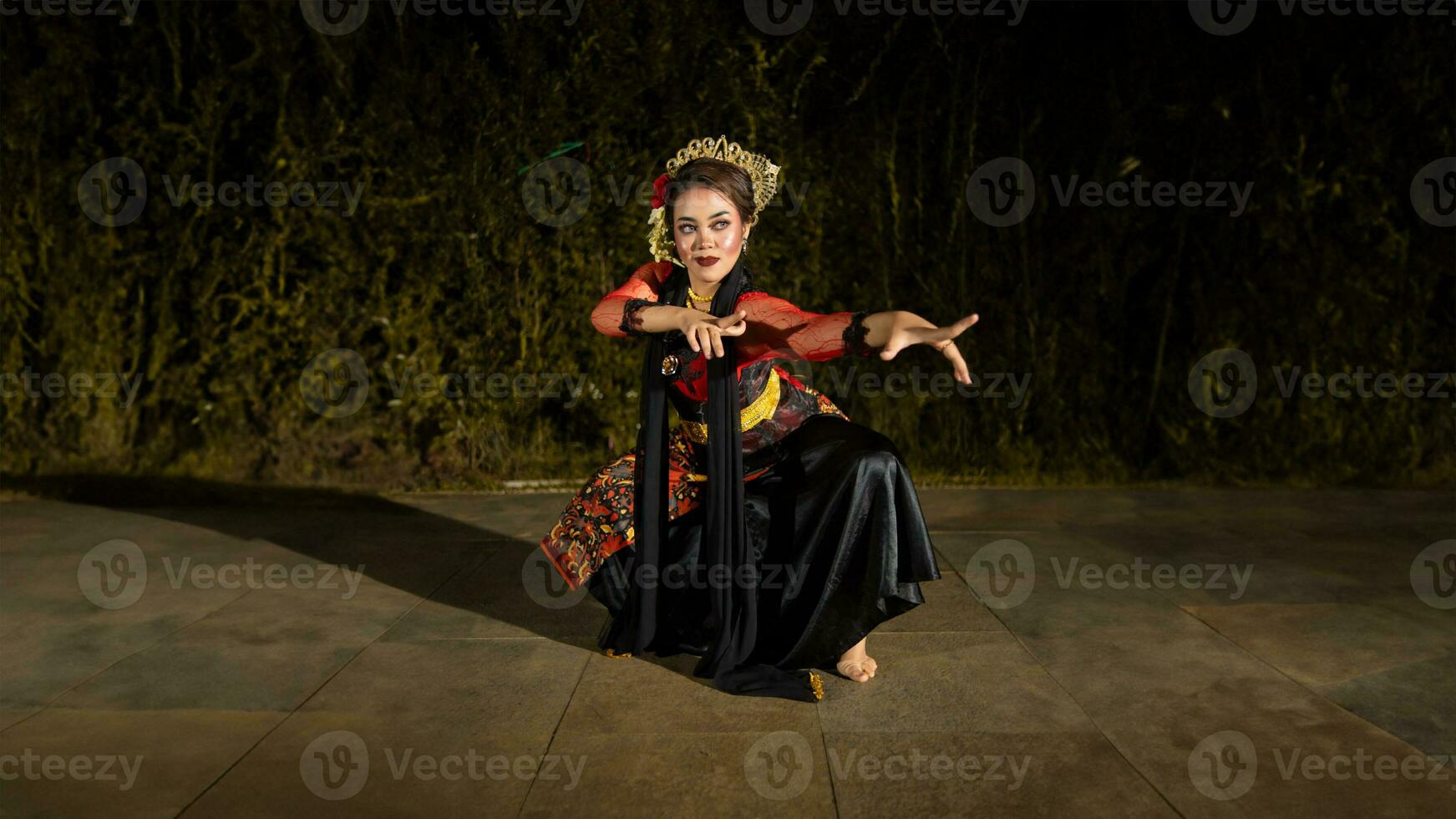uma javanese dançarino dentro uma vermelho traje apresentado uma dança este cativado a público com dele habilidade foto