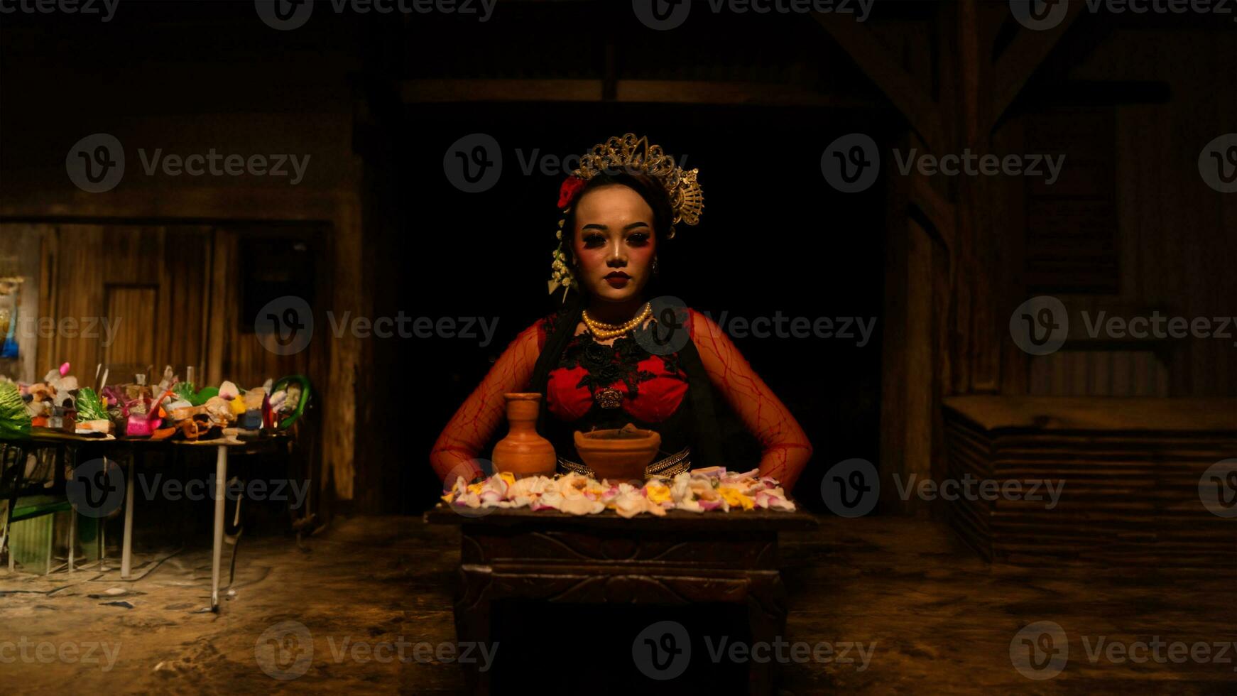 uma fêmea dançarino senta graciosamente e começa dela ritual dentro frente do lindo ofertas foto