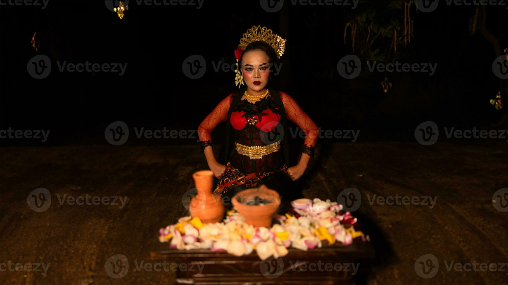 uma fêmea dançarino senta graciosamente e começa dela ritual dentro frente do lindo ofertas foto