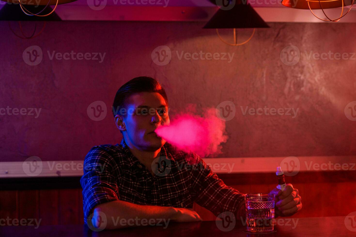 a homem fumaça a eletrônico cigarro às a vape fazer compras. foto