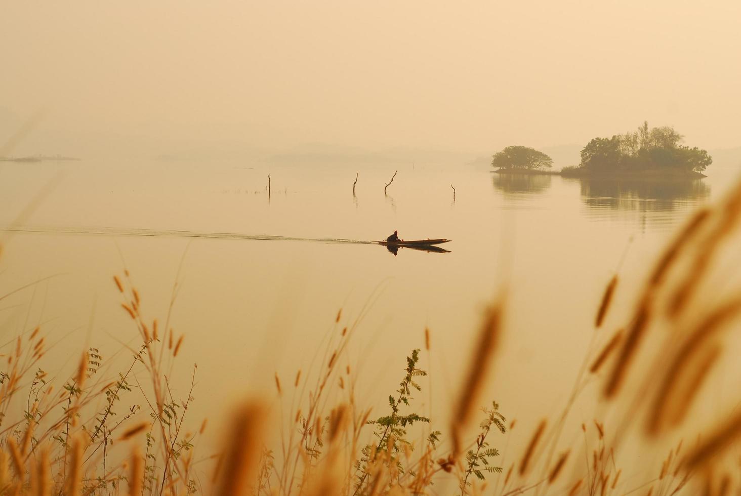 bela vista sombras luz barco de cauda longa nascer do sol no parque nacional da represa srinakarin kanchanaburi, tailândia foto