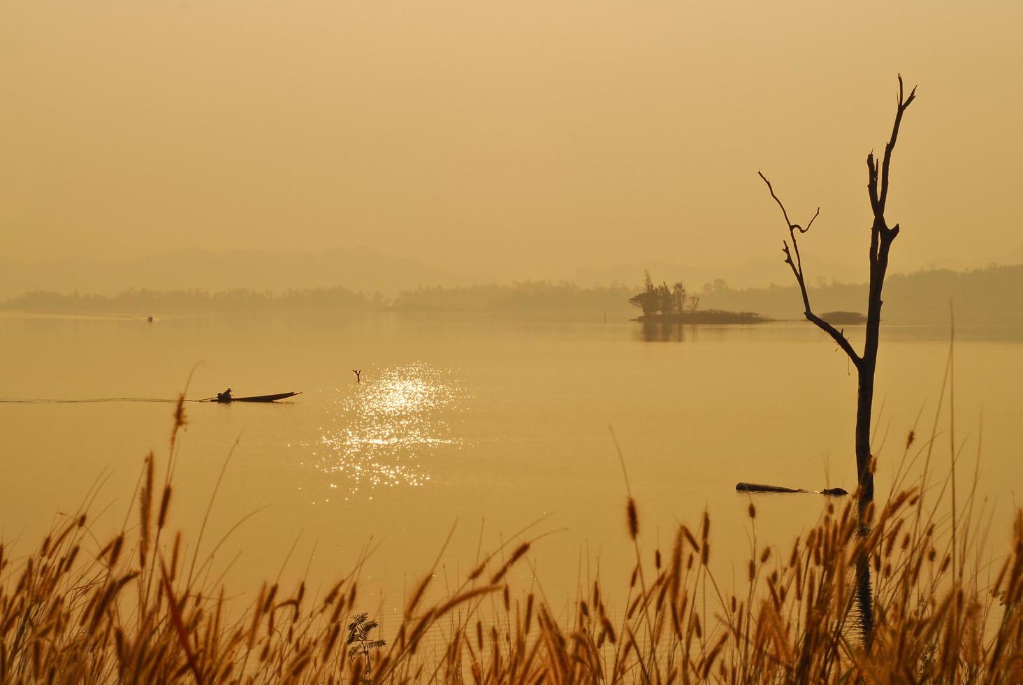 bela vista sombras luz barco de cauda longa nascer do sol no parque nacional da represa srinakarin kanchanaburi, tailândia foto