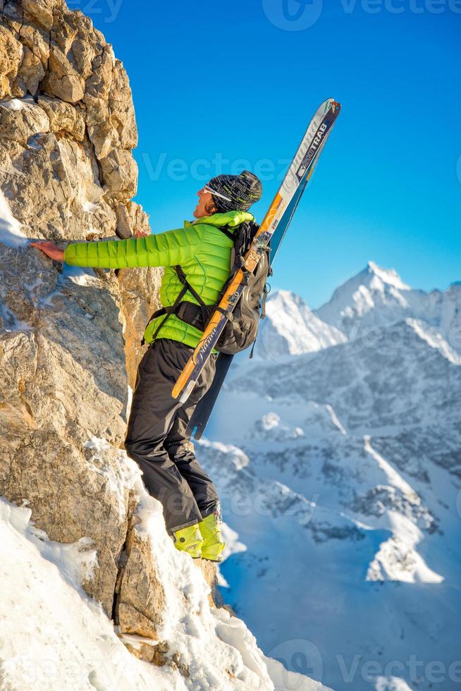 esquiador o escalador com esquis na mochila foto