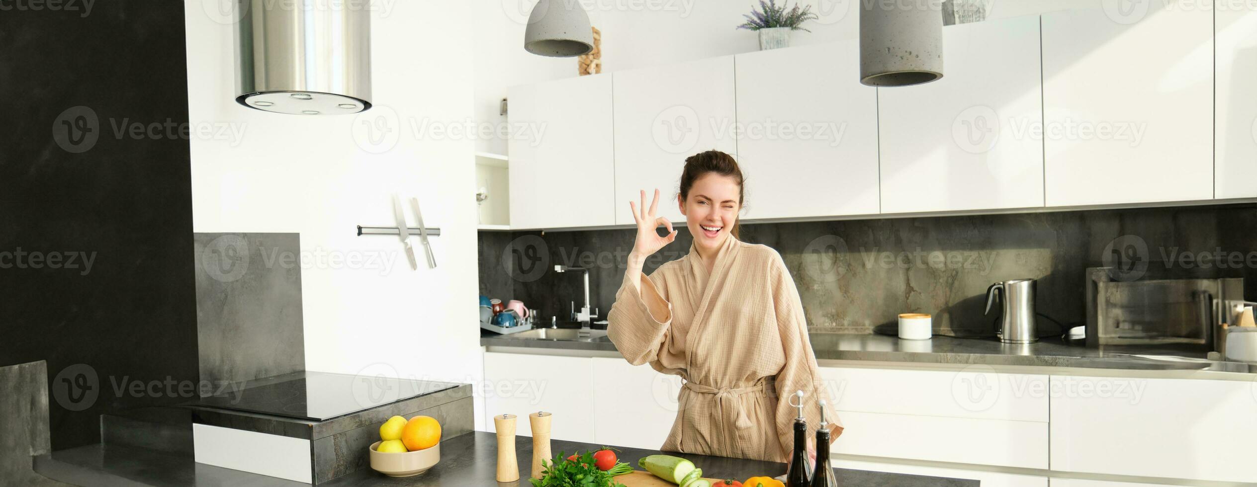 retrato do lindo jovem mulher dentro dela casa roupas, cortar vegetais, segurando faca e corte abobrinha, cozinhando dentro cozinha, preparando Comida para família jantar foto