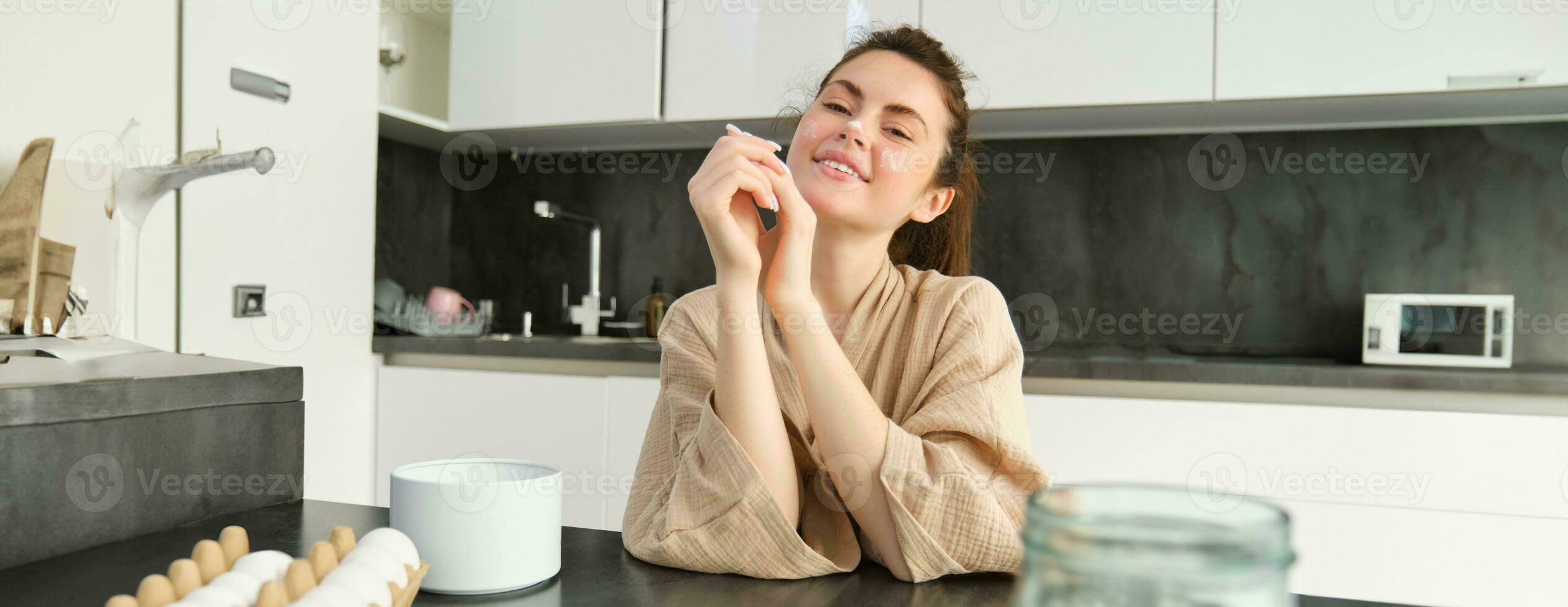 atraente jovem alegre menina cozimento às a cozinha, fazer massa, segurando receita livro, tendo Ideias foto