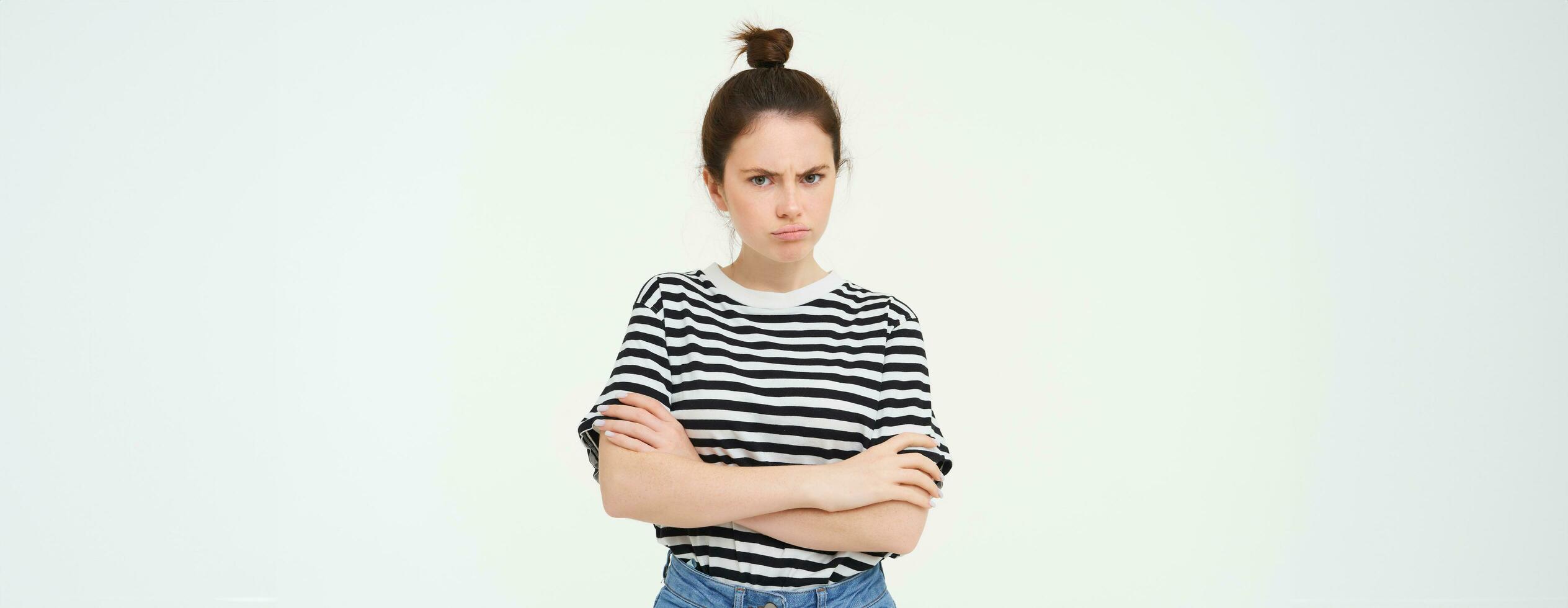 retrato do nervoso, ofendido jovem mulher, Cruz braços em peito e fazendo beicinho, olhando às Câmera com insultado face expressão, isolado sobre branco fundo foto