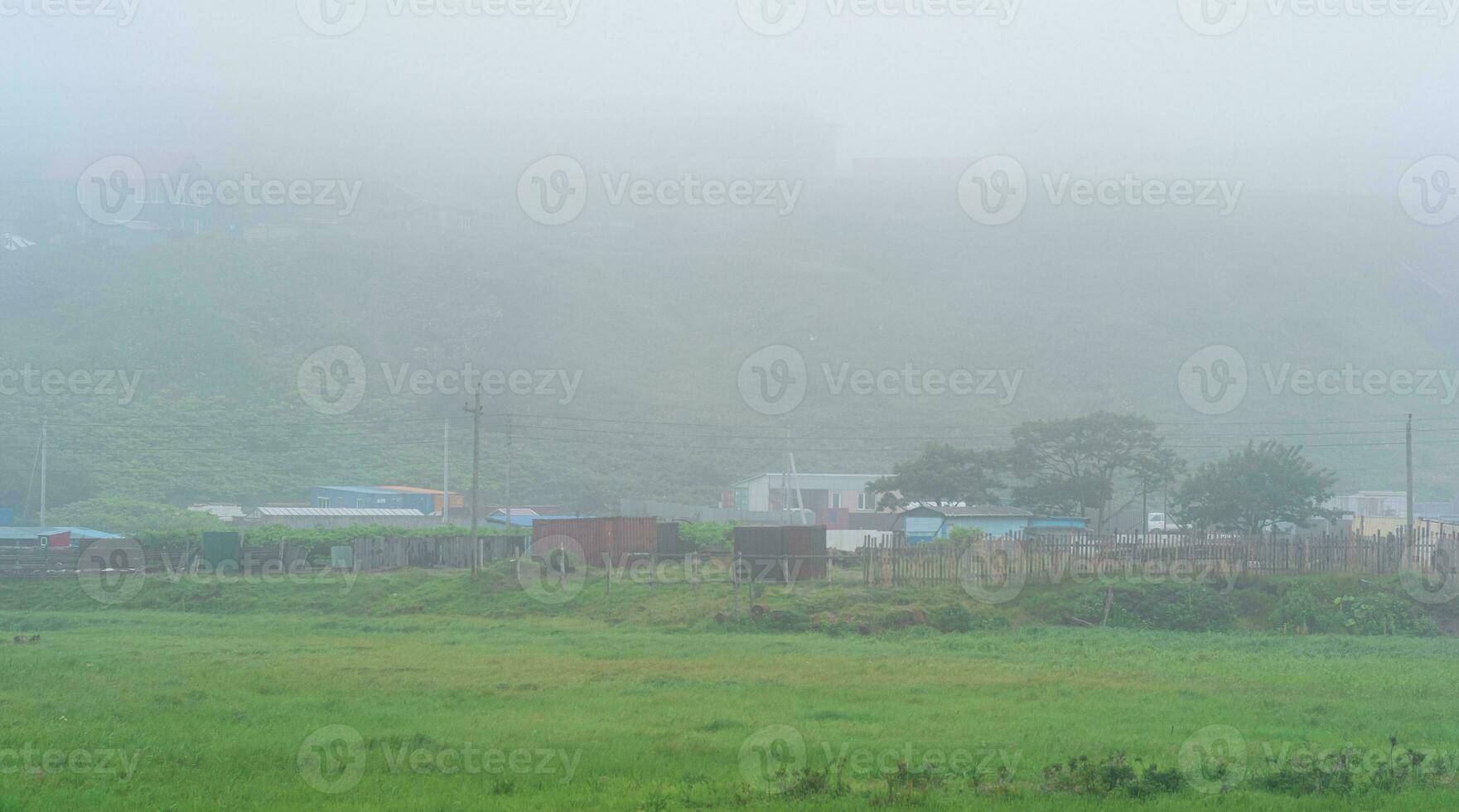 rural panorama com vegetal jardins e celeiros dentro Grosso névoa foto