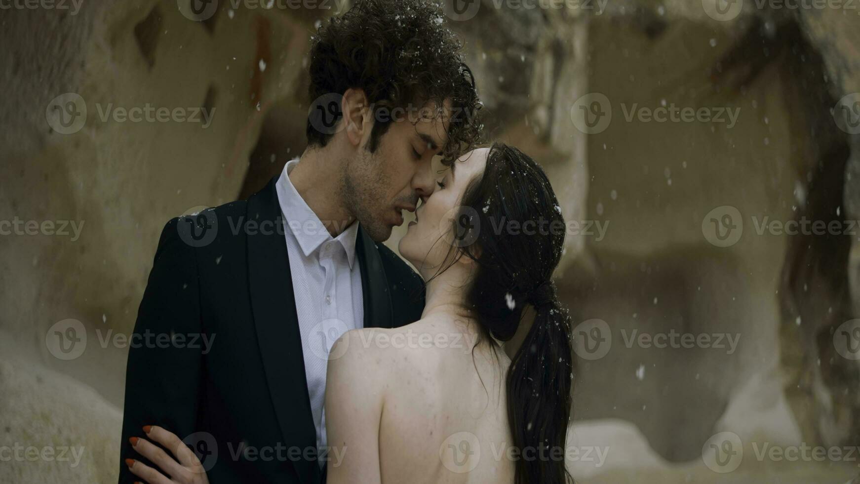 amoroso romântico Casamento casal abraçando e se beijando cada outro. Ação. lindo jovem homem e mulher debaixo a queda de neve perto cavernas. foto