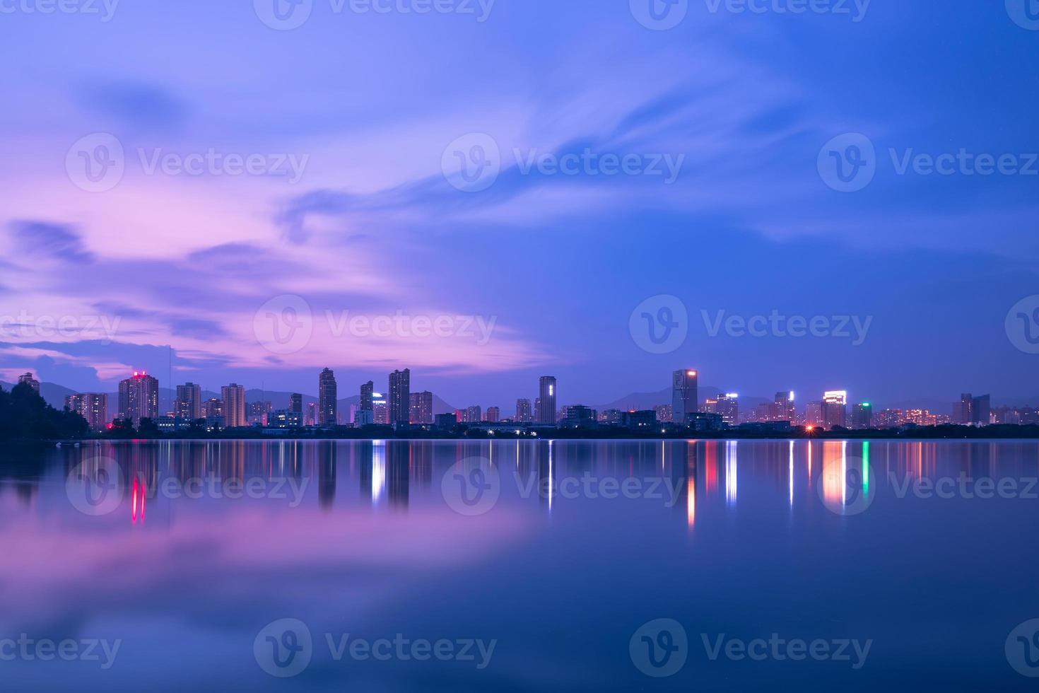 ao anoitecer, o lago reflete a visão noturna da cidade foto