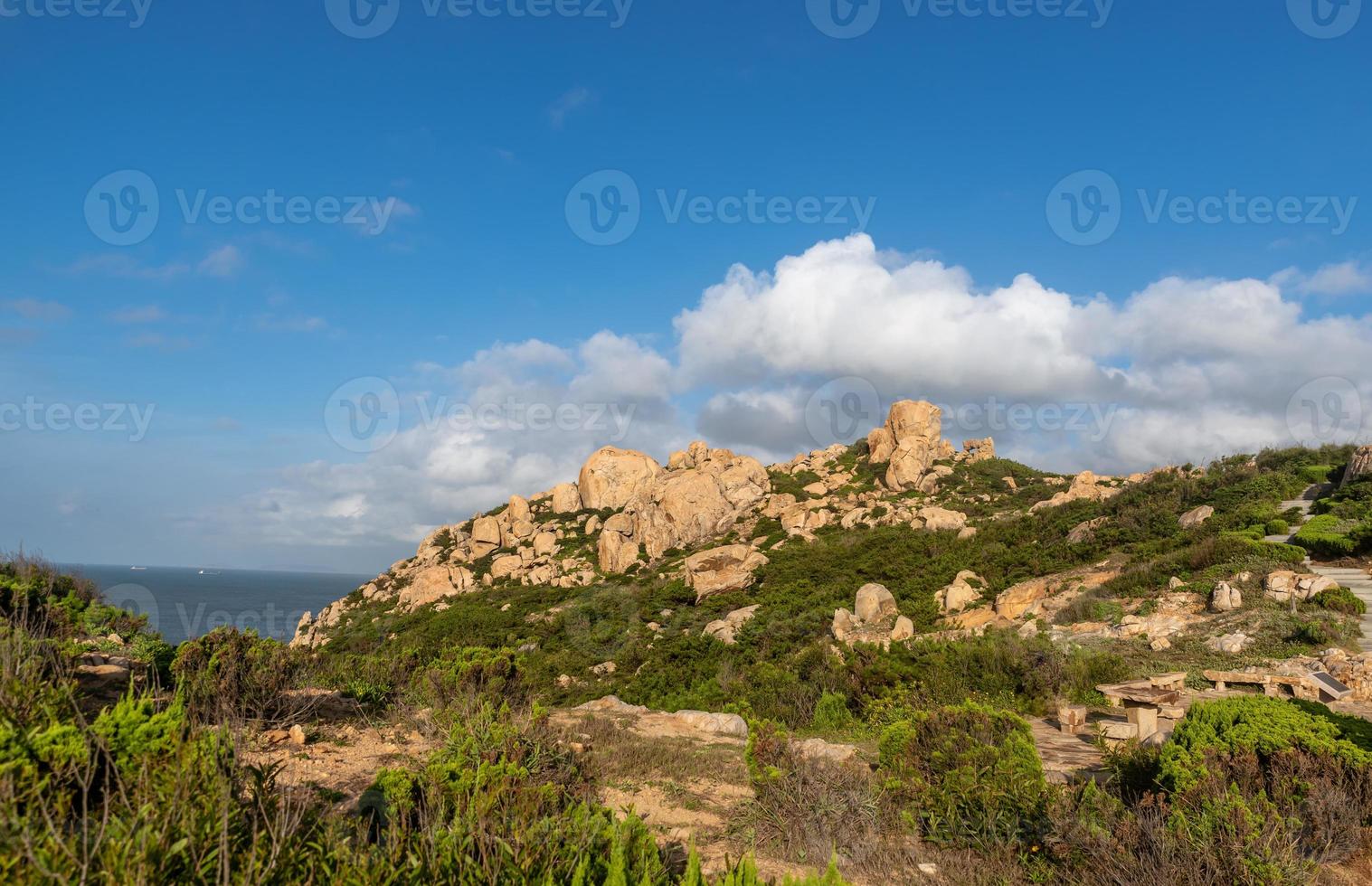 pedras de várias formas intemperizadas pelo mar sob o céu azul foto