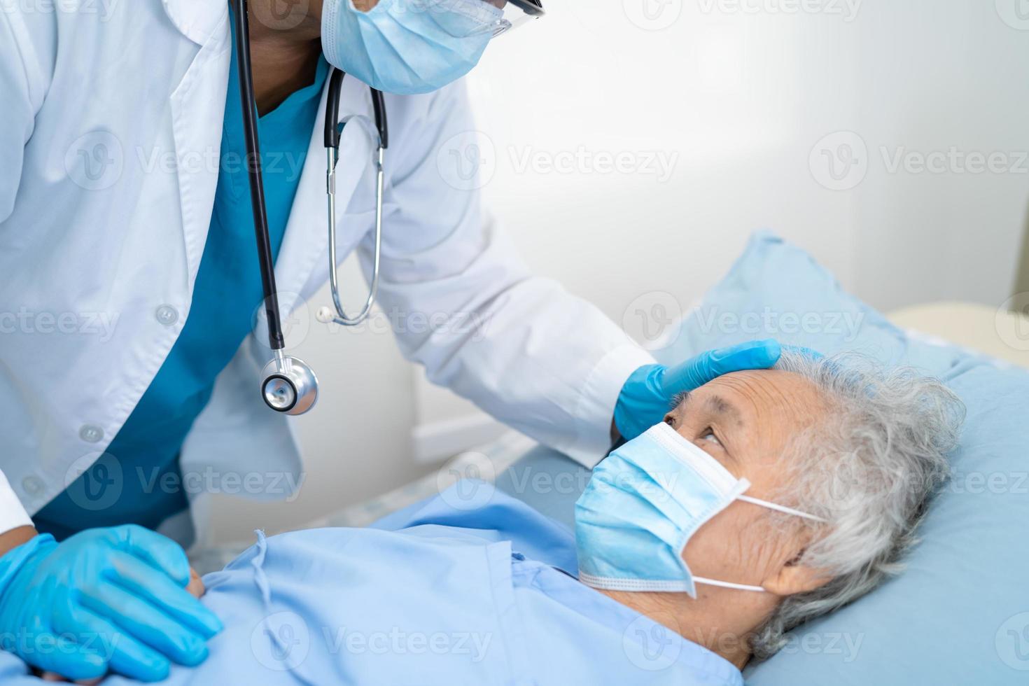 médico ajuda paciente asiático sênior ou idosa idosa usando uma máscara facial no hospital para proteger a infecção de segurança e matar o coronavírus covid-19. foto
