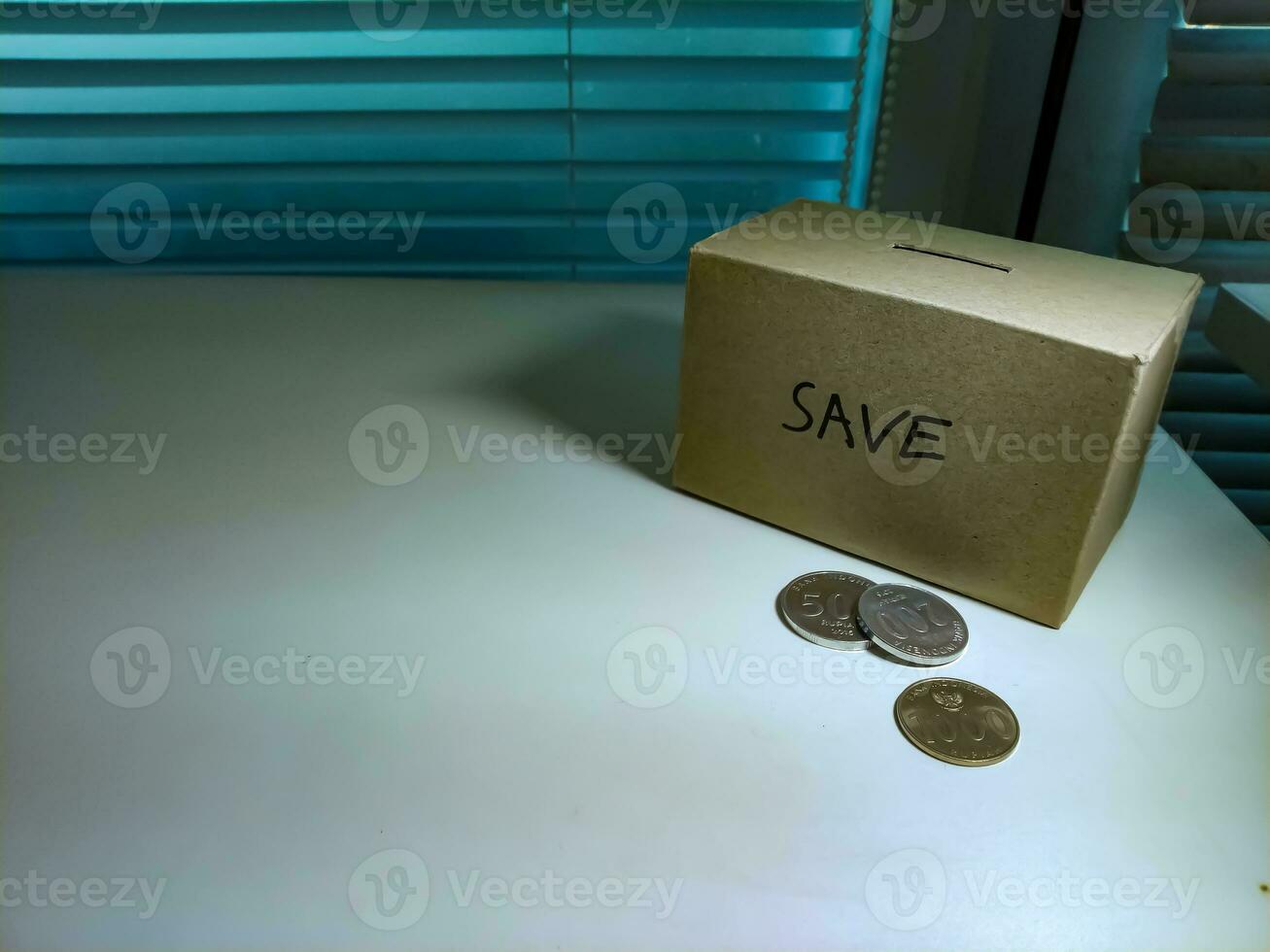 uma caixa do poupança e moedas empilhado em uma mesa, para fundo objetivo foto
