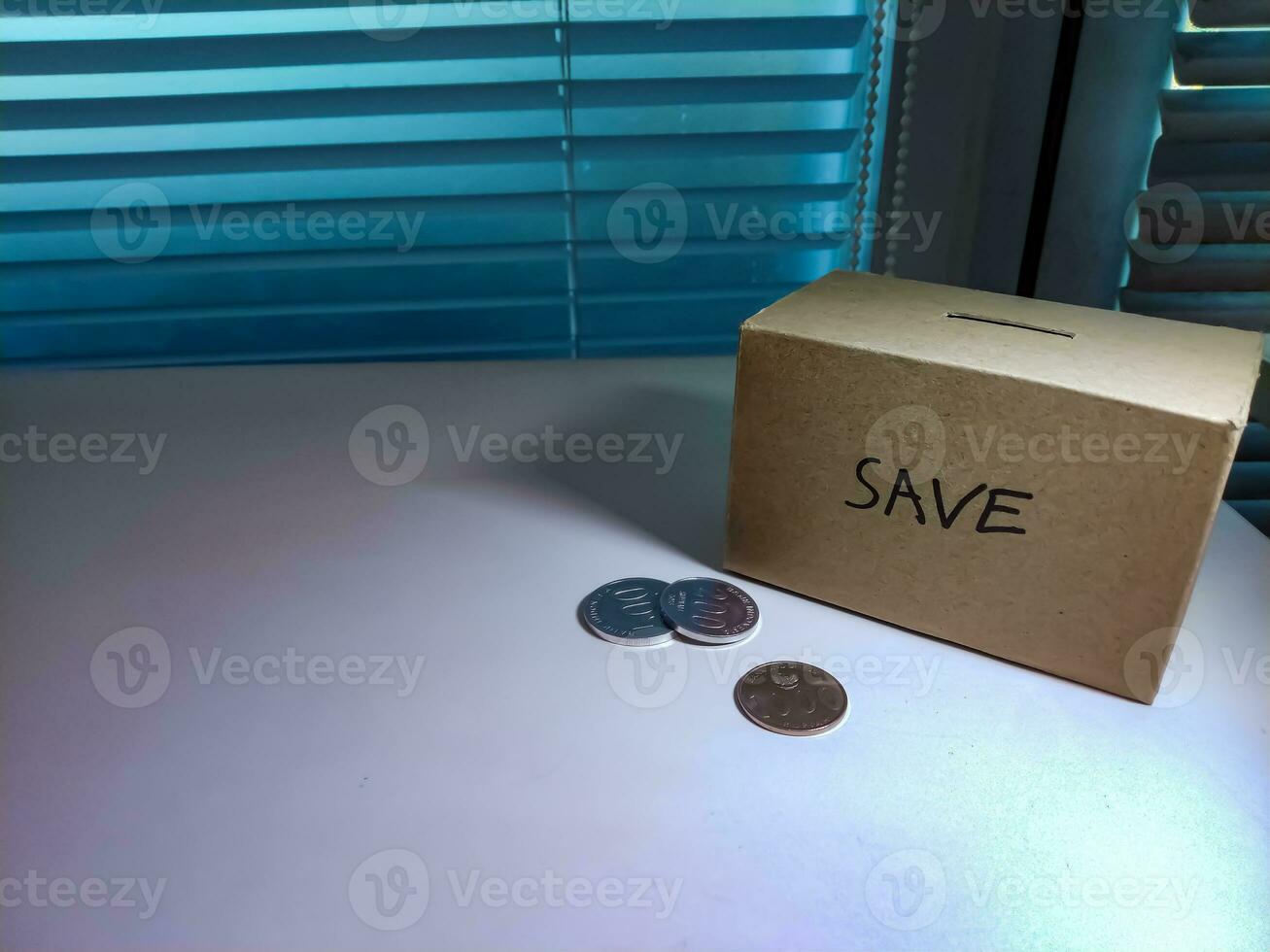 uma caixa do poupança e moedas empilhado em uma mesa, para fundo objetivo foto