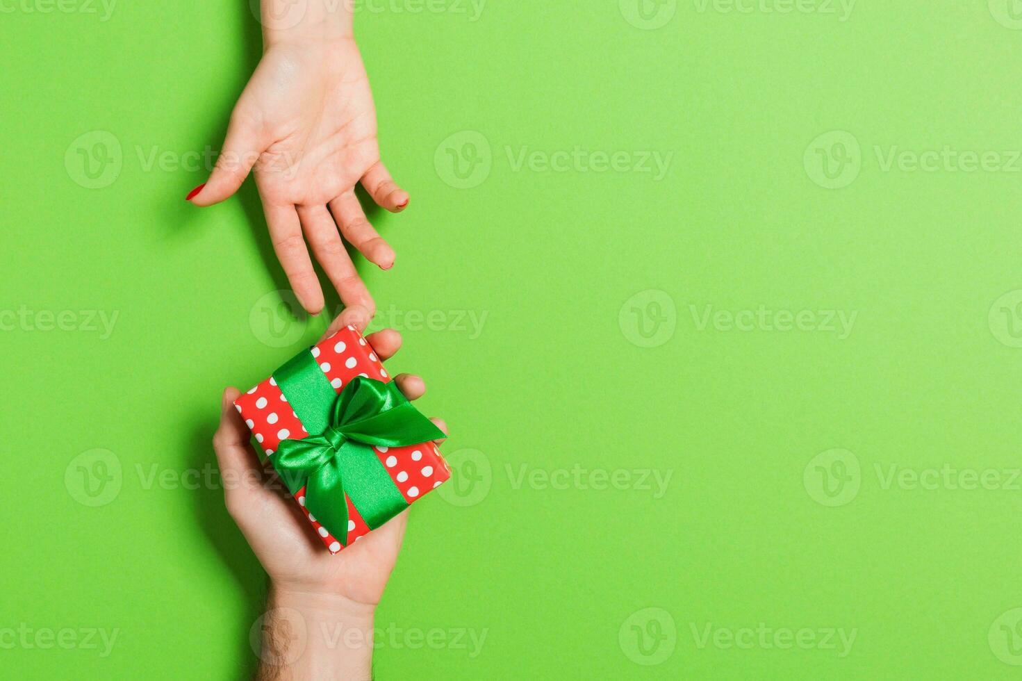 topo Visão do uma homem e uma mulher segurando uma presente caixa em colorida fundo. amor e relação conceito. cópia de espaço foto