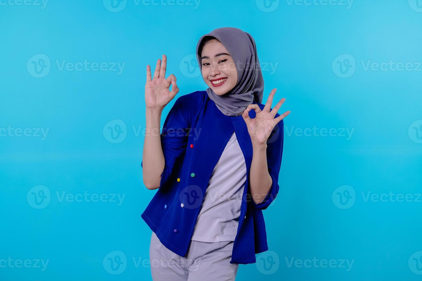 mulher alegre com hijab mostrando sinal de ok, sorrindo, diga sim, incentive a comprar algo, faça um gesto correto foto