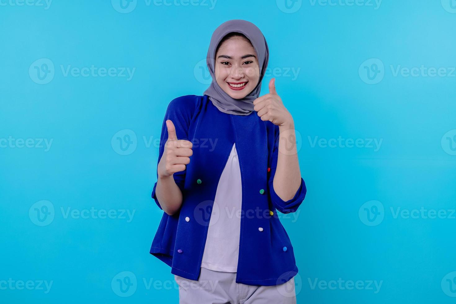 solidária e otimista feliz linda mulher asiática usando hijab polegares para cima, impressionada e encantada foto