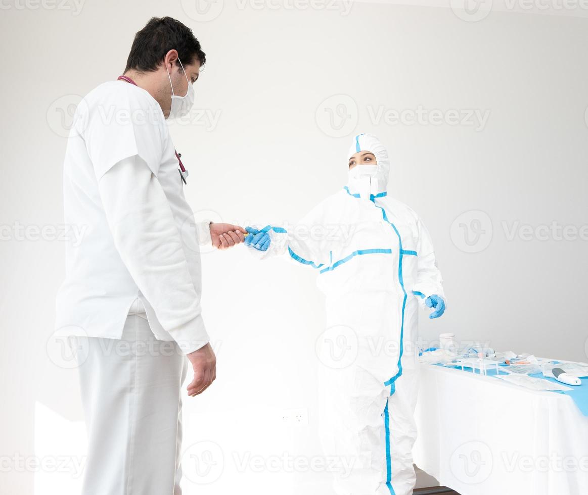 médico em traje de proteção trabalhando na sala médica com um colega foto