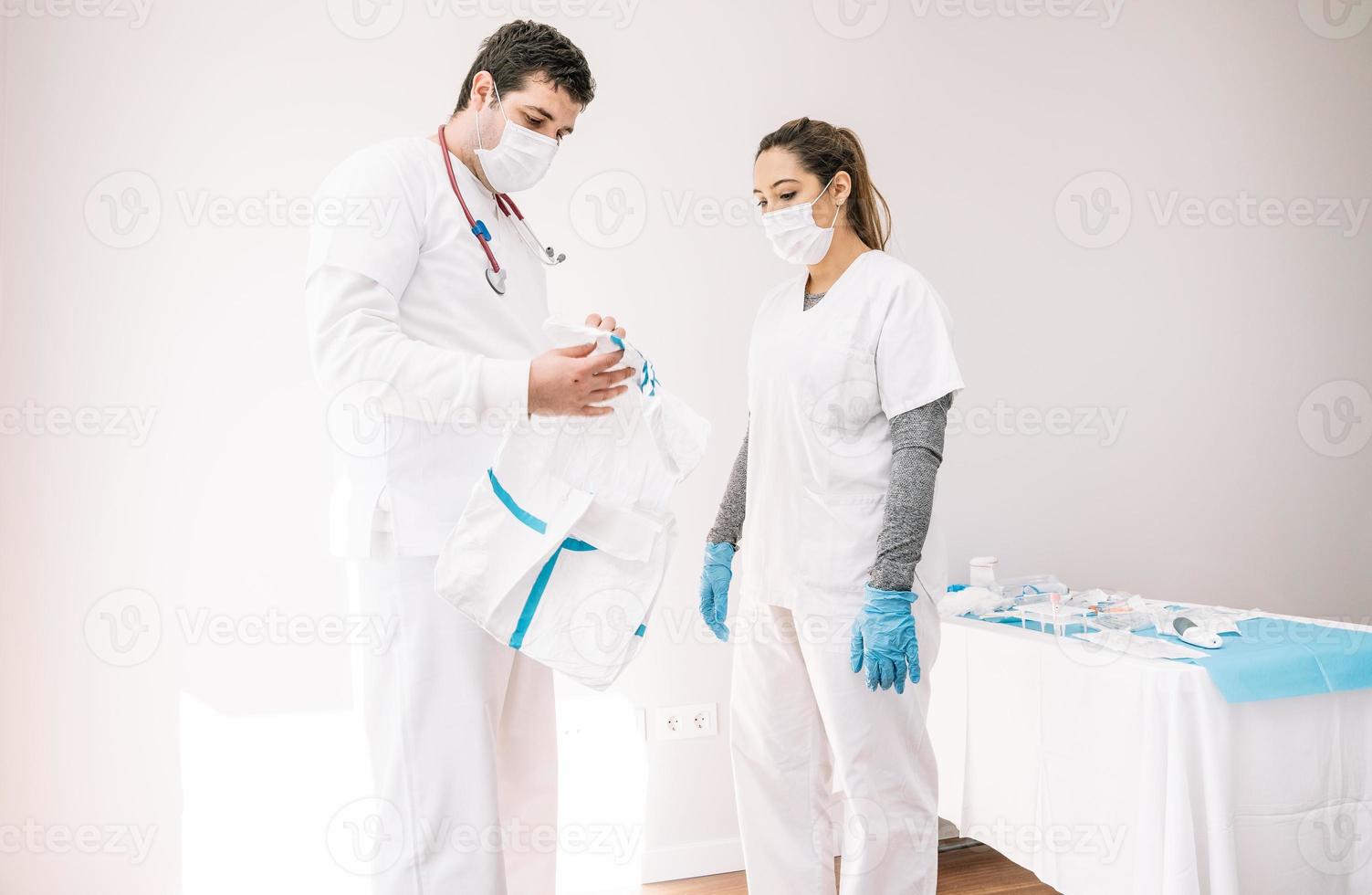 médicos mascarados em pé com roupa protetora foto