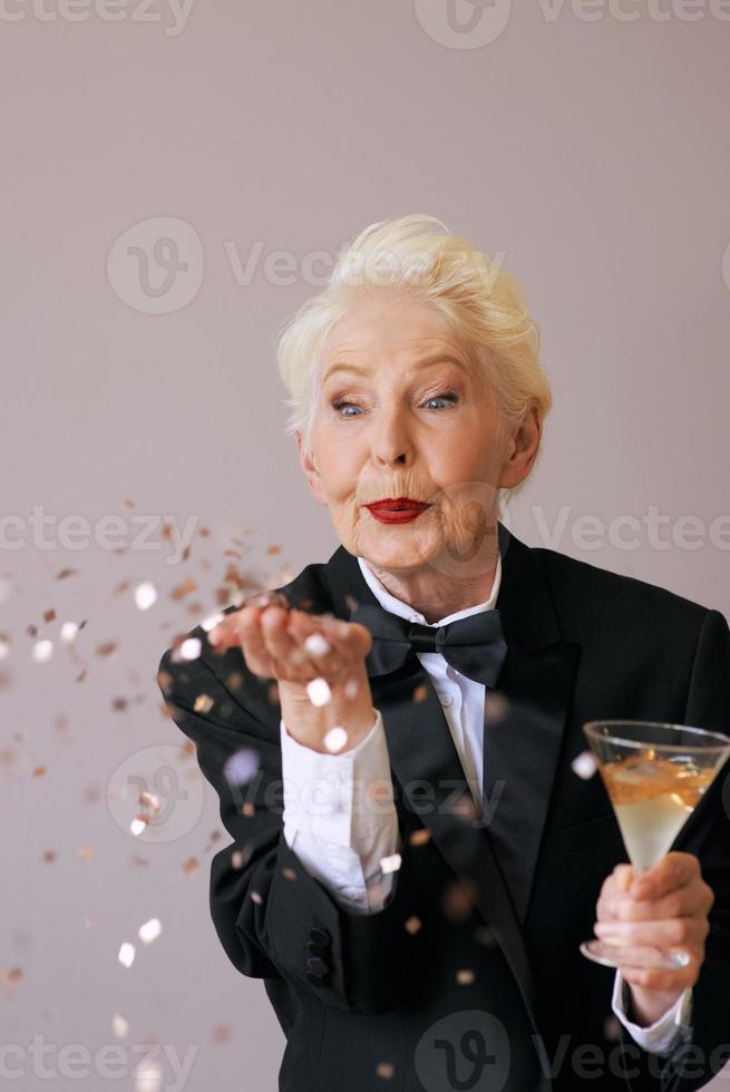 cabelo curto elegante sênior mulher de smoking com glitter, comemorando o ano novo. diversão, estilo de vida, estilo, conceito de idade foto