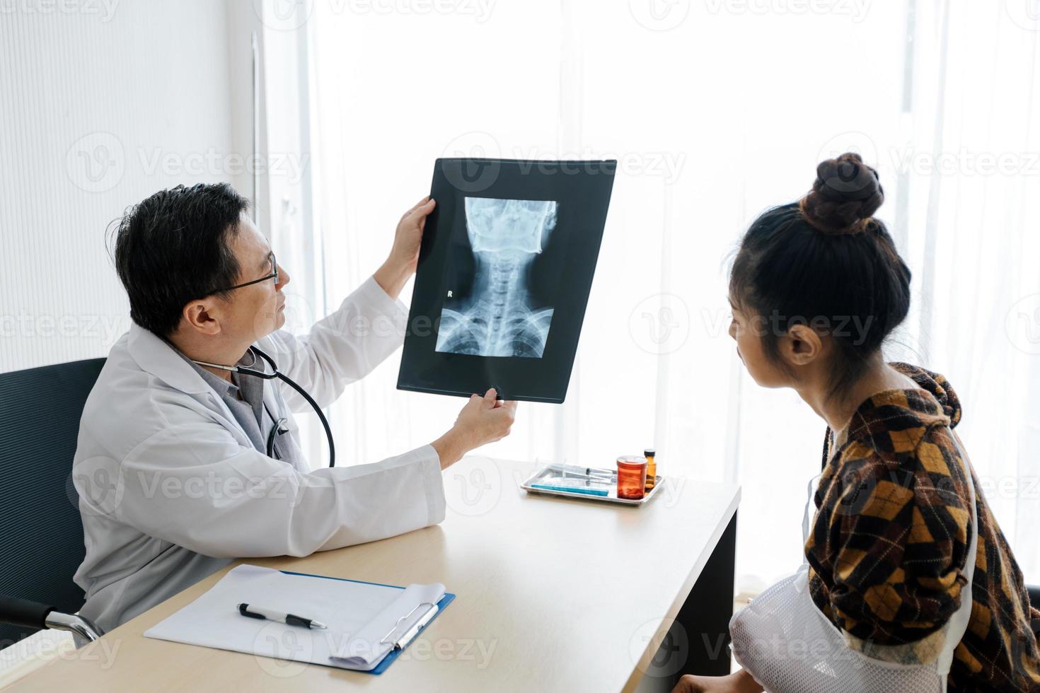 o médico está explicando sobre os resultados das radiografias do cérebro a uma paciente em seu consultório em hospitais foto