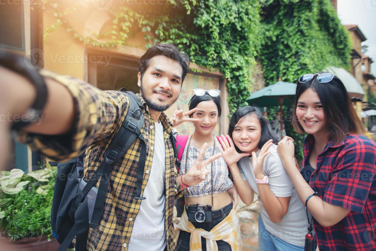 grupo asiático de jovens com mochilas de amigos caminhando juntos e amigos felizes tirando fotos e selfie, tempo de relaxamento na viagem do conceito de férias