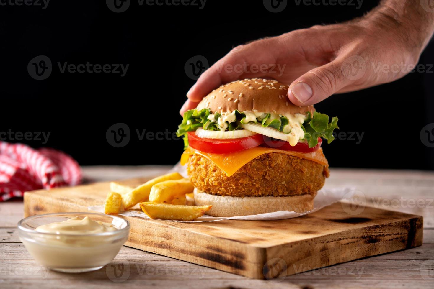 hambúrguer de frango crocante com queijo e batata frita foto