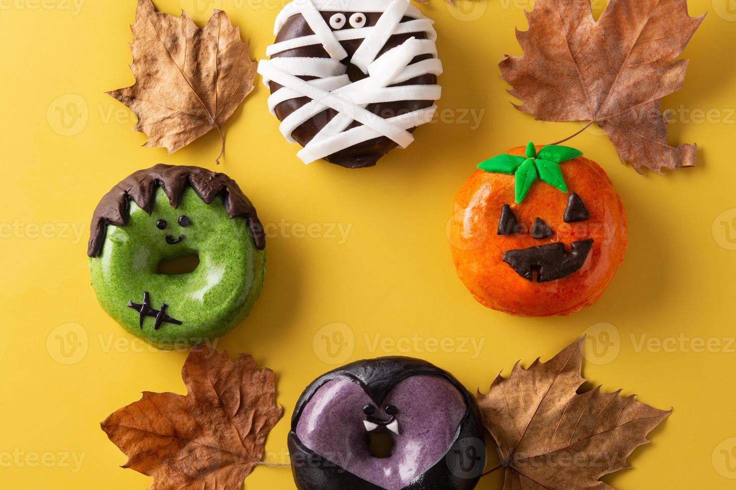 variedade de donuts de halloween e folhas de outono foto