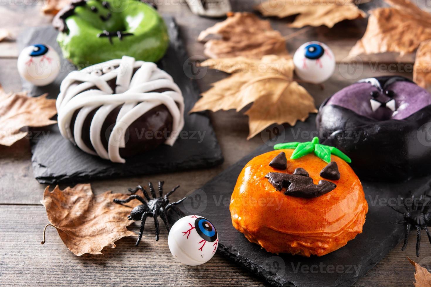 vários donuts de halloween e folhas de outono foto