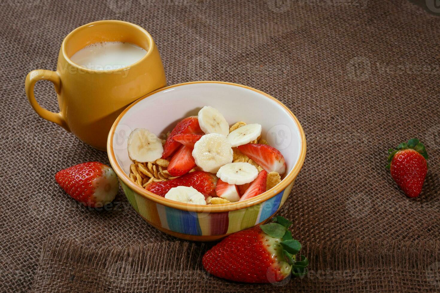 saudável café da manhã. flocos de milho, fresco morangos, banana e leite foto