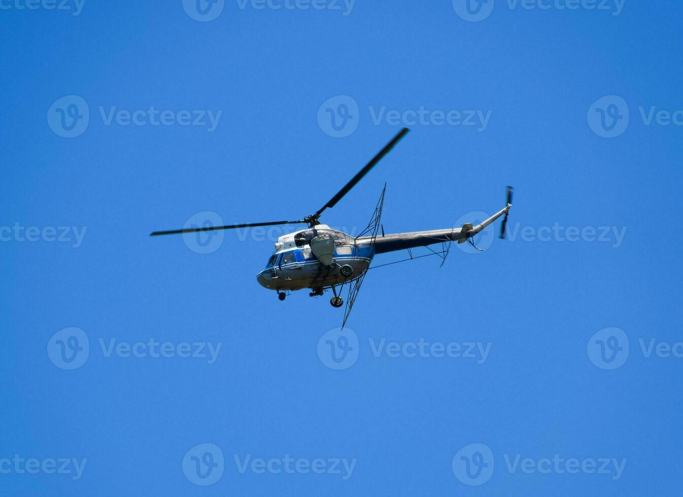 uma helicóptero do agrícola aviação é vôo dentro a azul céu. foto