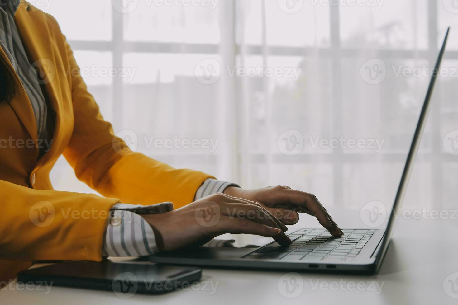 o negócio mulher usando Móvel telefone durante trabalhando em computador portátil computador, surfar a Internet, procurando o negócio dados às moderno escritório. ásia empresária conectados trabalhando em computador às local de trabalho foto