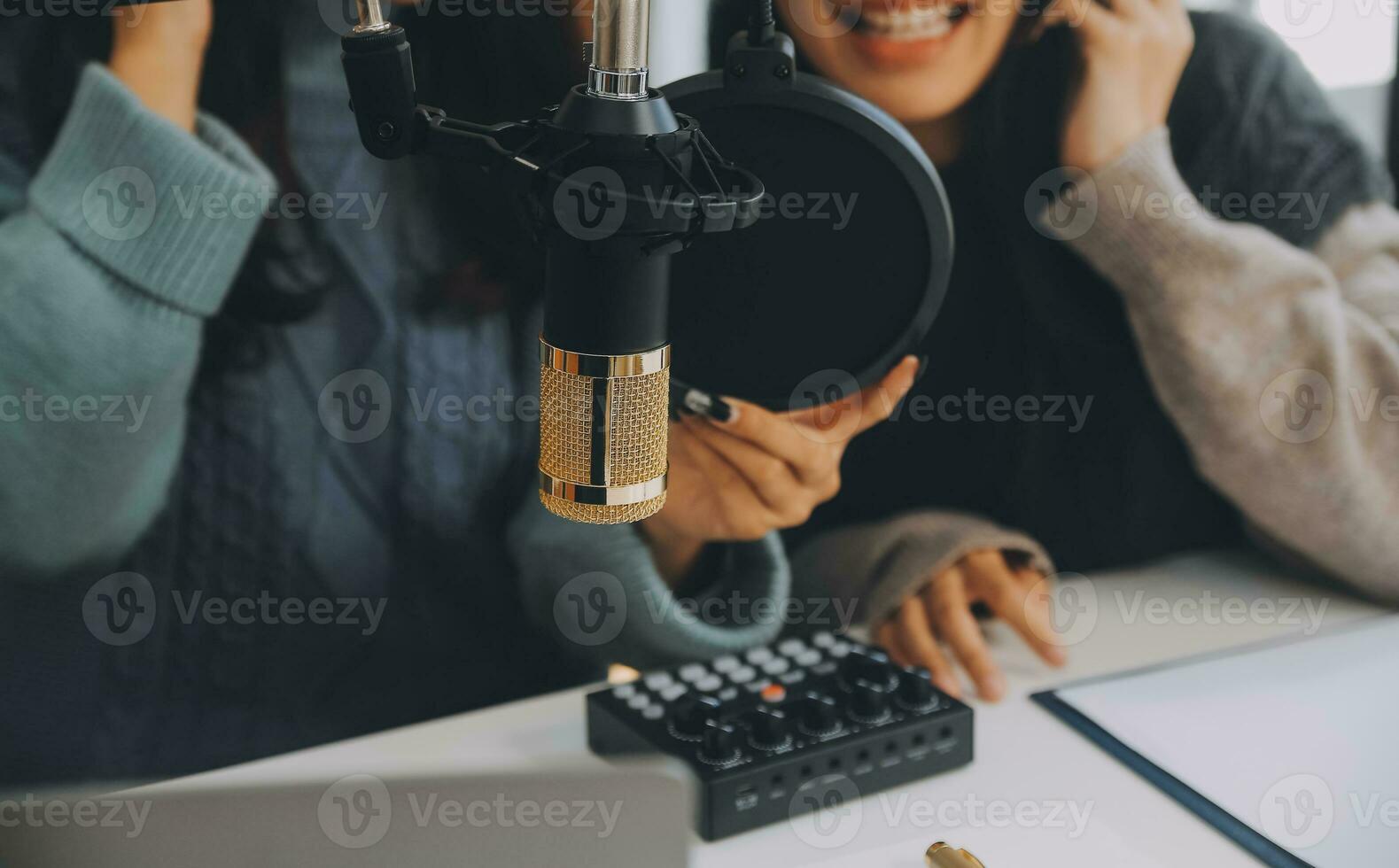 mulher gravando um podcast em seu laptop com fones de ouvido e um microscópio. podcaster feminino fazendo podcast de áudio de seu estúdio em casa. foto