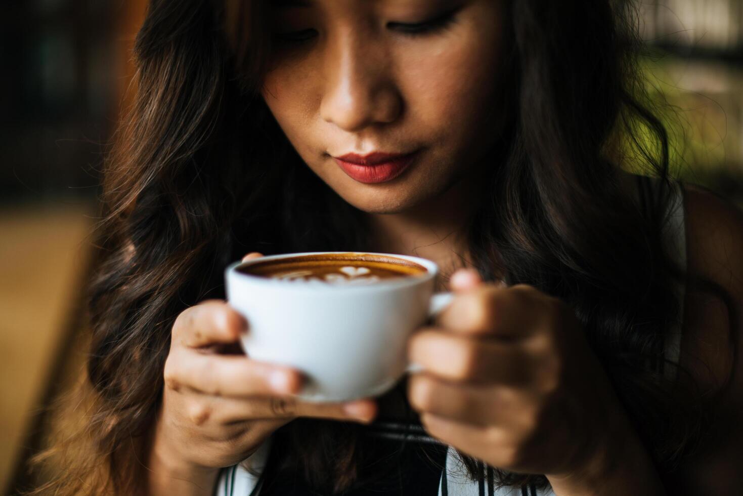 retrato de mulher asiática sorrindo relaxando em uma cafeteria foto