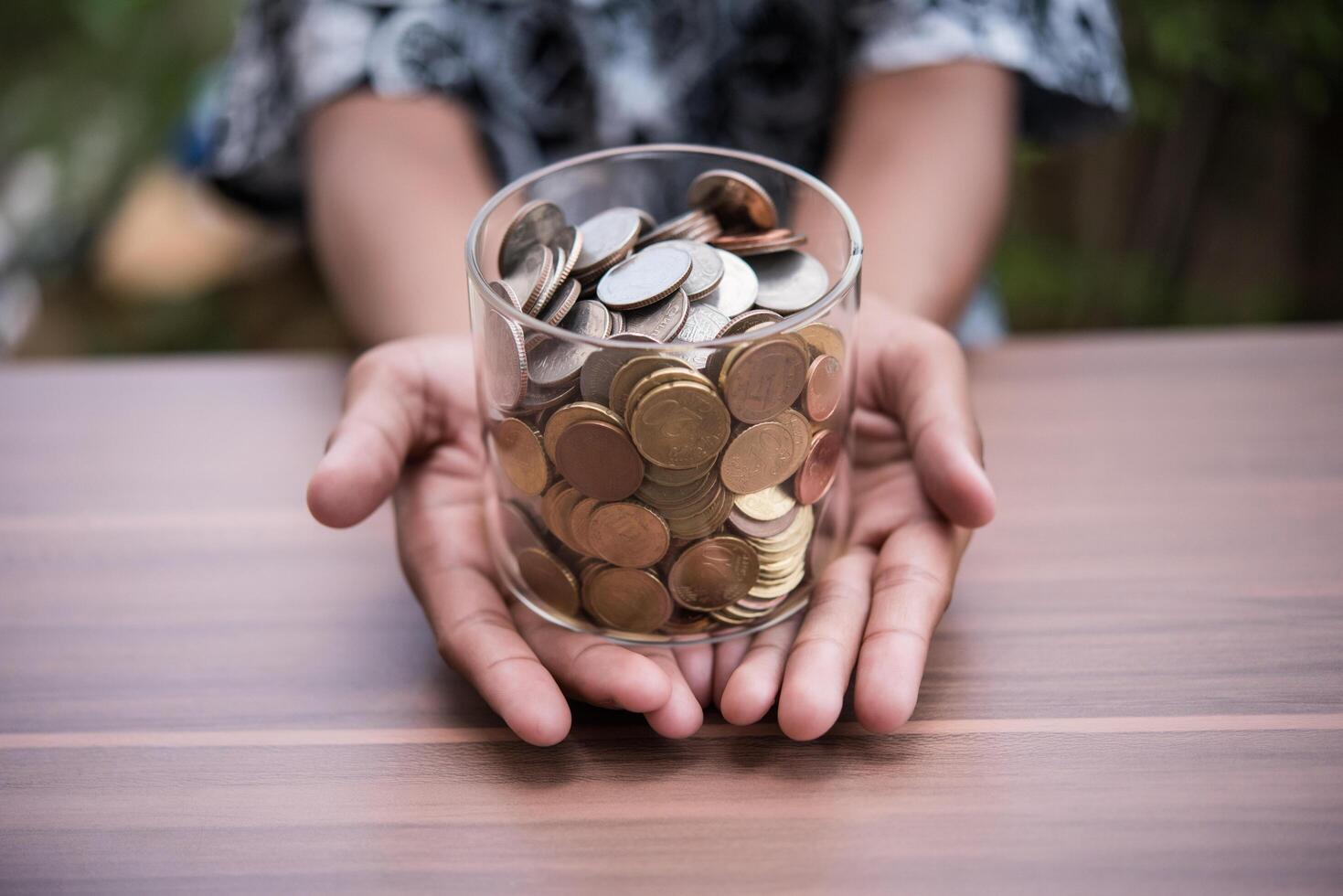 mão colocando moedas na jarra com a etapa da pilha de dinheiro crescendo e economizando dinheiro foto