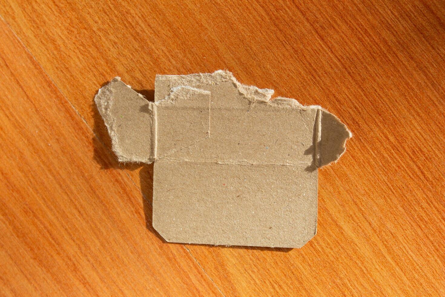 rasgado reciclado cartão papel peça em de madeira fundo foto