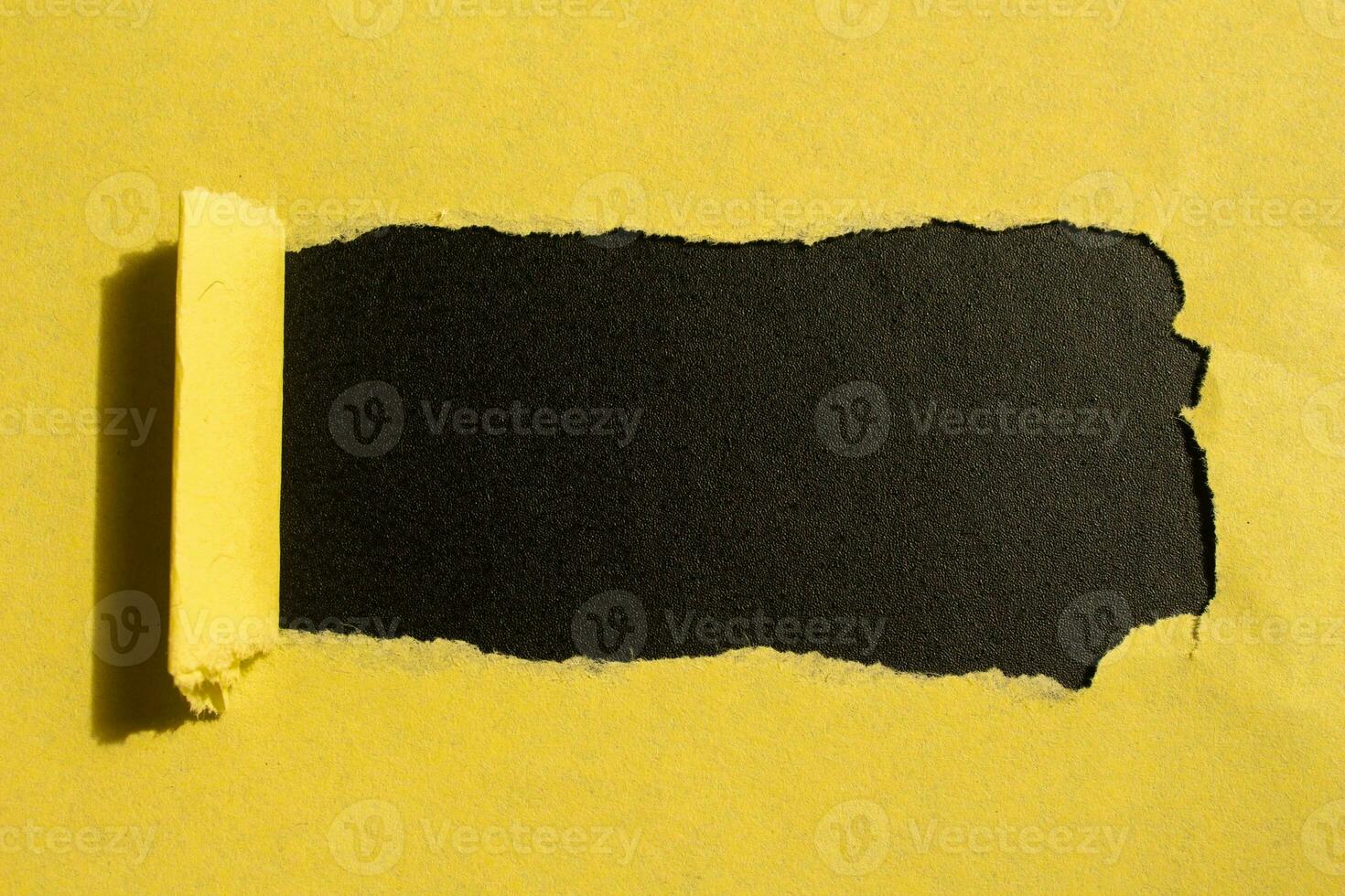amarelo rasgado papel orifício em uma Preto fundo com cópia de espaço para seu texto foto
