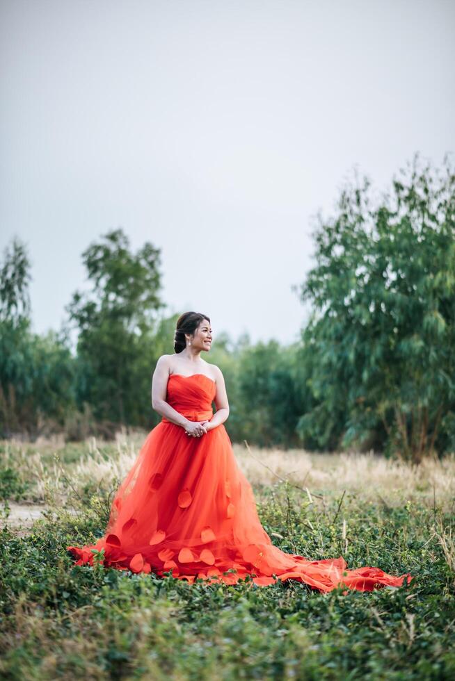 linda noiva em vestido de noiva postando na natureza foto